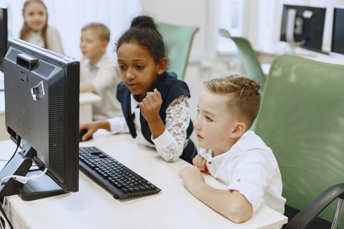 Elementary students learning together on classroom computers