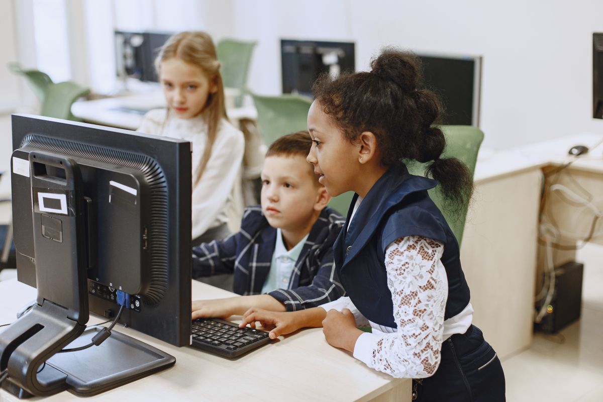 Children collaborating at computers in class