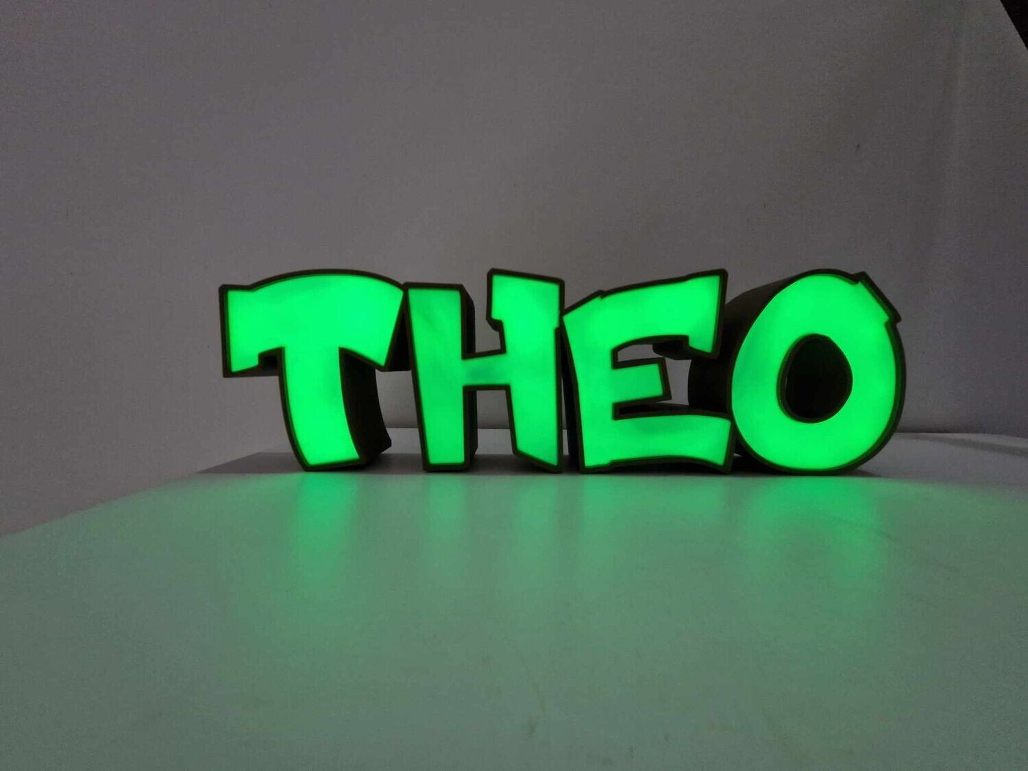 Green illuminated personalized name sign reading Theo
